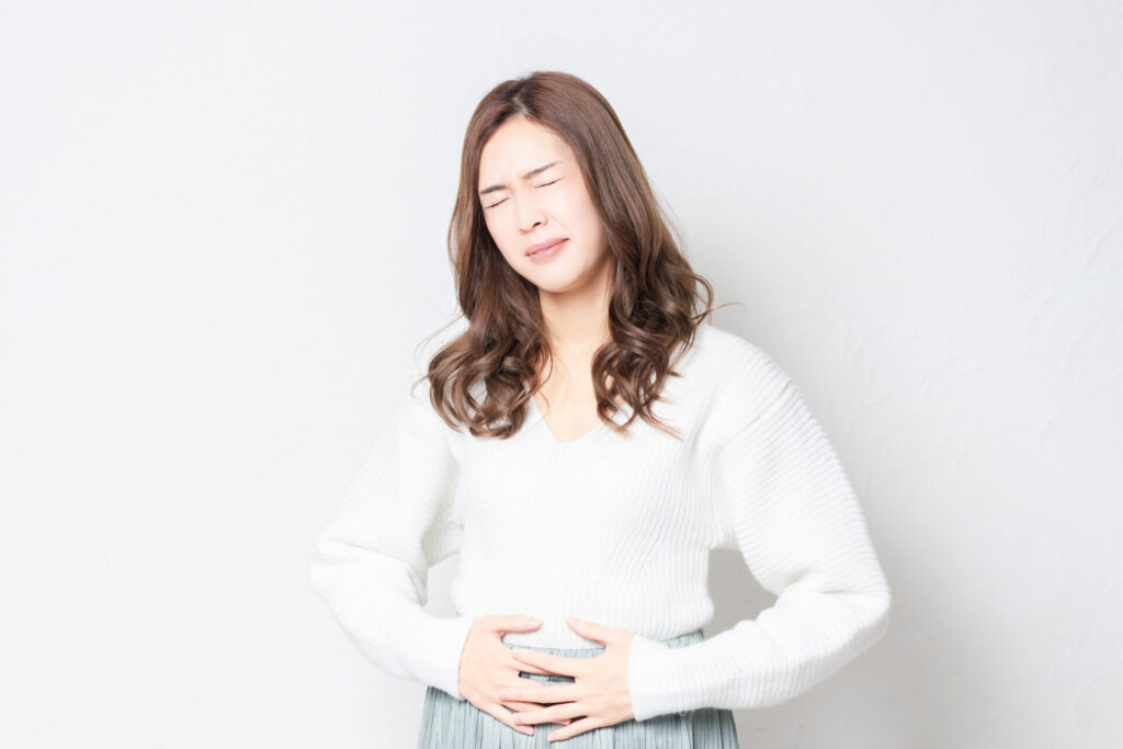 お腹に手を当てる若い女性
